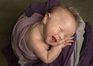 smling newborn girl during a photo shoot.