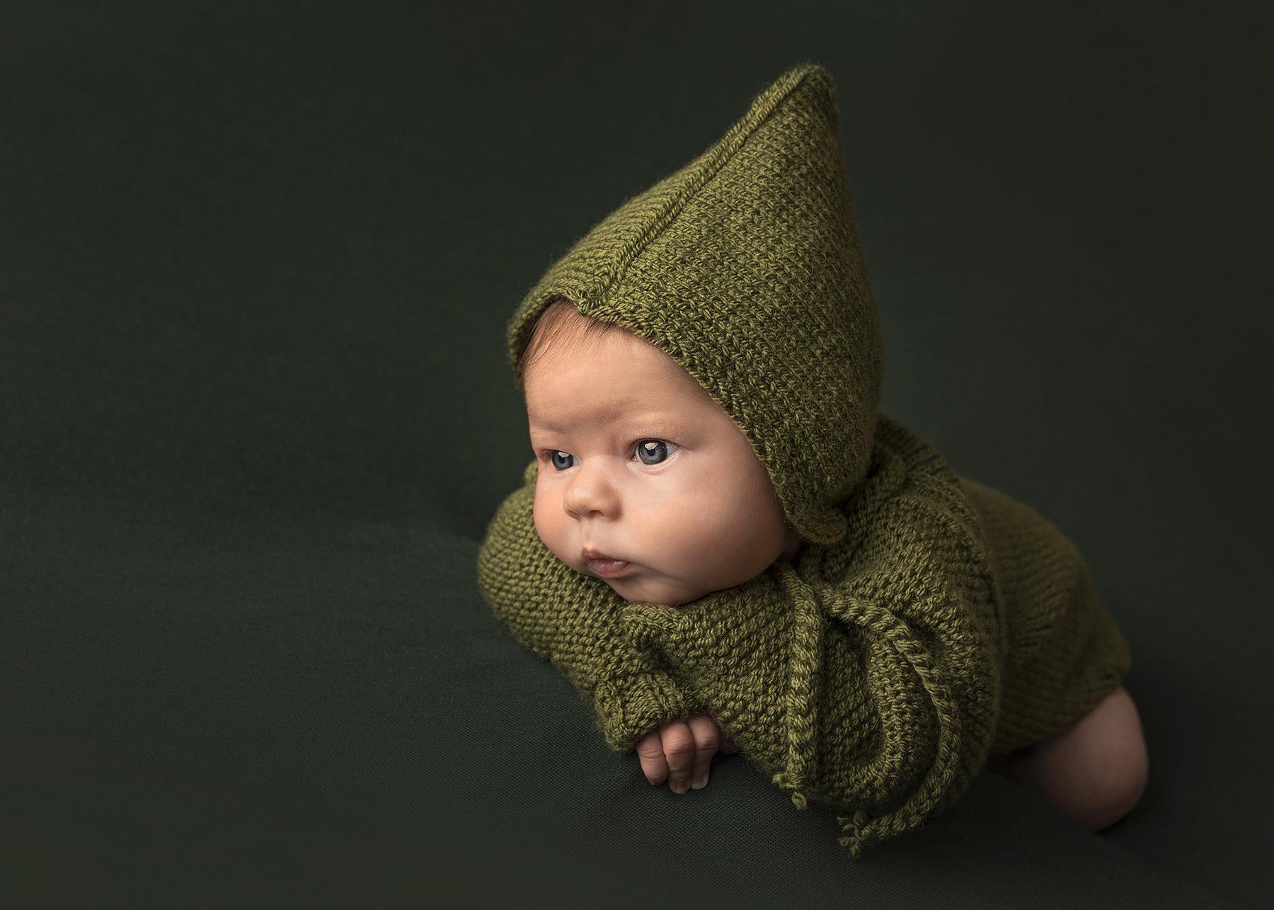 baby girl in green pixy hat during her newbonr photo shoot in Hertford.